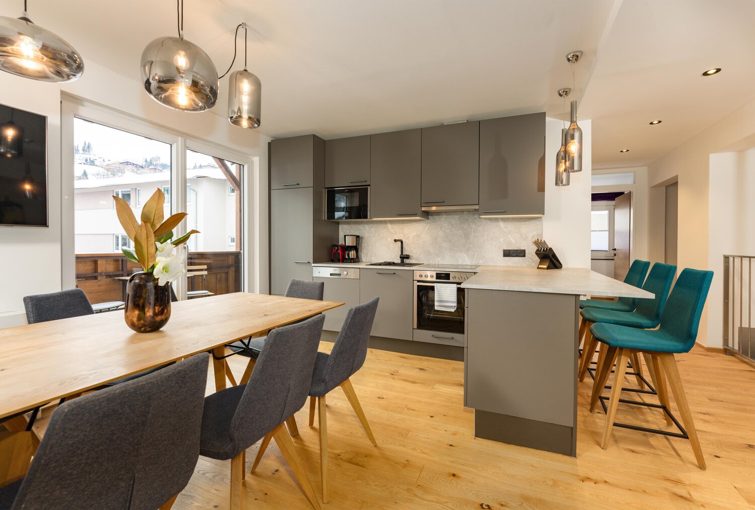 Modern kitchen with gray cabinets and wooden dining table