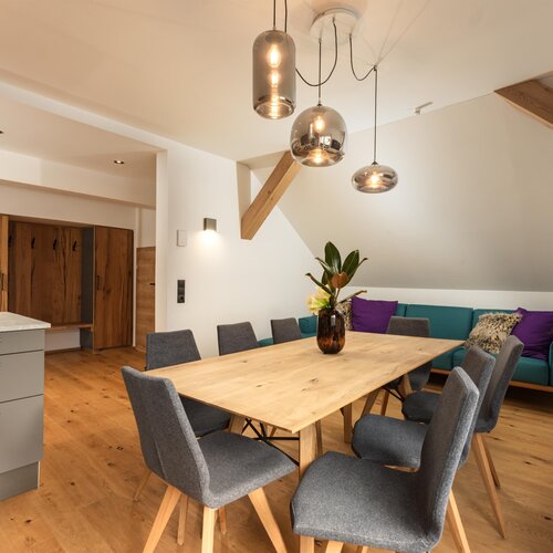 Open-plan dining area with wooden table and grey chairs