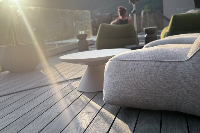 Dachterassen-Lounge mit modernem Sitzmöbel und runder Tisch bei Sonnenuntergang