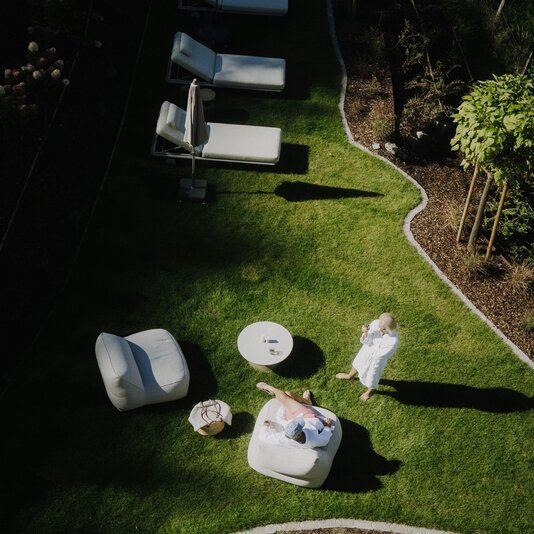 Aerial view of sunlit backyard lounge area with chairs