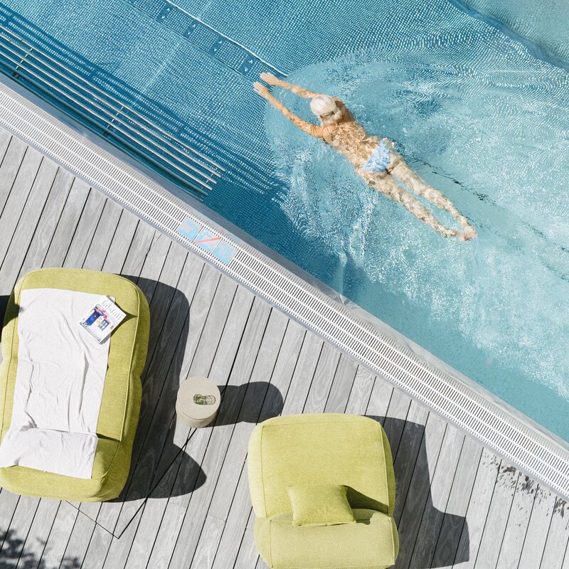 Aerial view of a poolside deck with green loungers