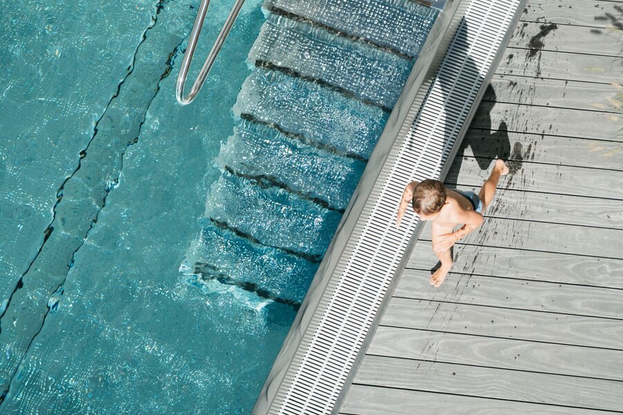 Draufsicht auf das Schwimmbecken mit Leiter und Kind