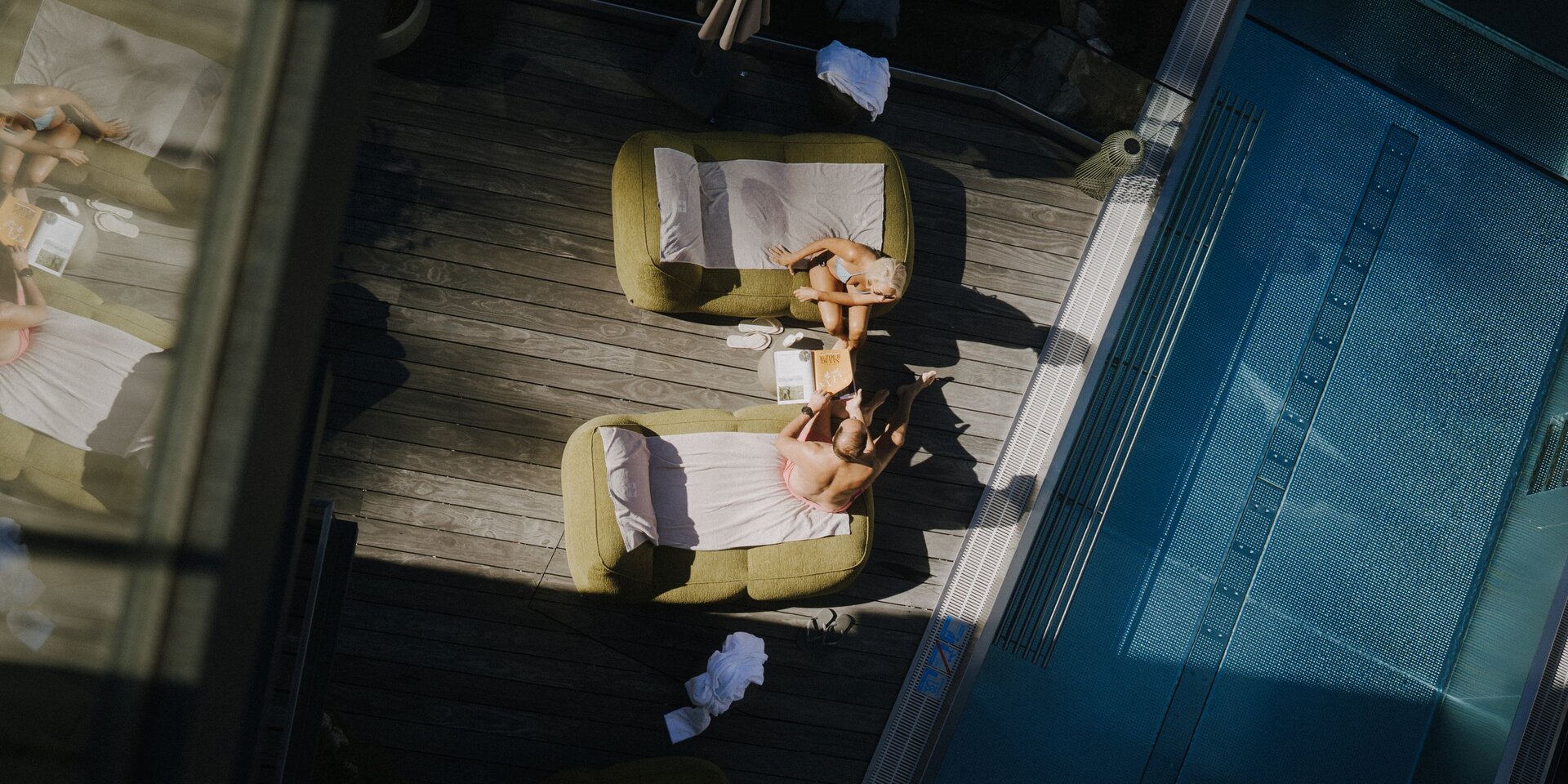 Luftaufnahme von Personen, die auf Liegen am Pooldeck entspannen