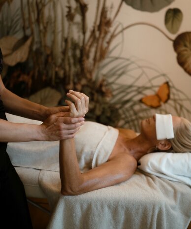 Therapist massages a client's hand during spa treatment