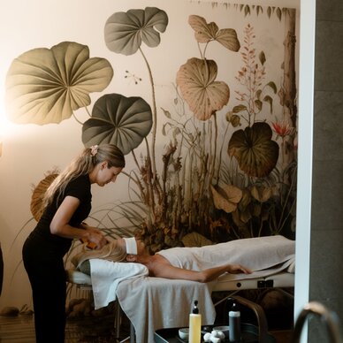 Therapeutin führt Behandlung an Patientin auf Massagetisch durch