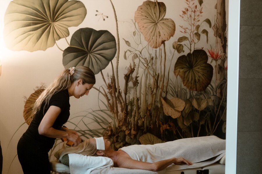 Therapist performs treatment on client lying on massage table