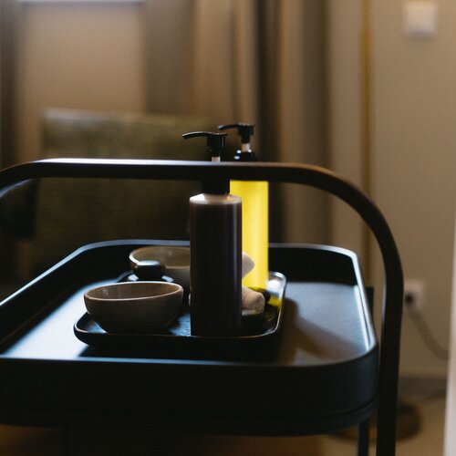 Servierwagen im Hotelzimmer mit Pumpflasche und Schalen